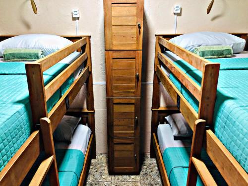 a room with two bunk beds and a dresser at Hostel Ilha do Amor in Fernando de Noronha