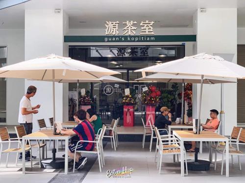 コタキナバルにあるJY Vacation Home New & Modern Suite Infinity pool-Sutera Avenueの傘をさして座る人々