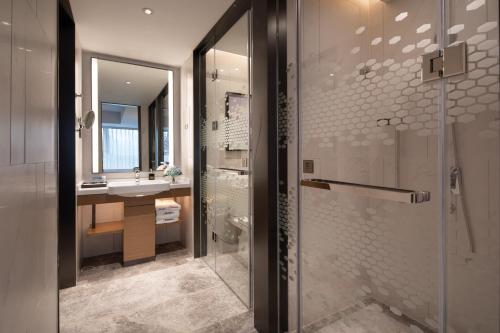 a bathroom with a shower and a sink at Hampton by Hilton Yixing Renmin Middle Road Branch in Yixing