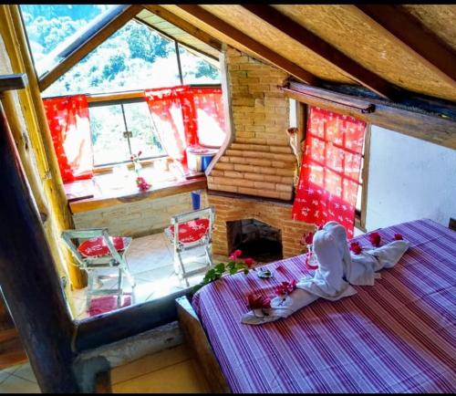 a room with a bed and a table and chairs at Sítio Monte Moriá Pousada in Santo Antônio do Pinhal