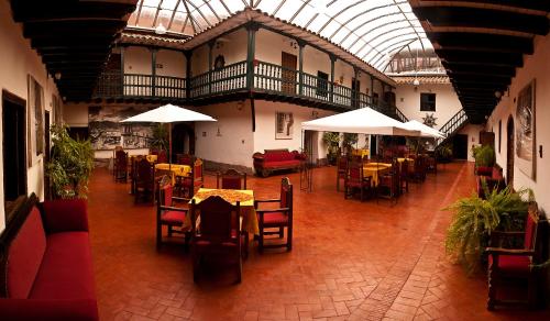 un restaurante vacío con mesas, sillas y sombrillas en Hotel Marqueses, en Cusco