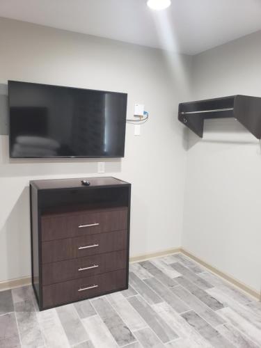 a living room with a flat screen tv on a wall at Budget Inn & Suites Baton Rouge in Baton Rouge