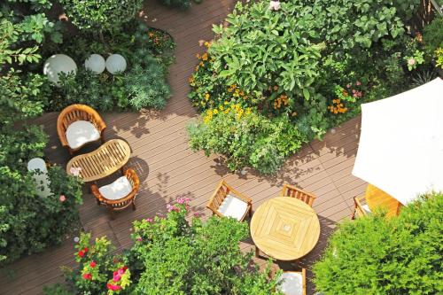 a patio area with chairs, tables, and plants at Hotel Alhambra in Paris