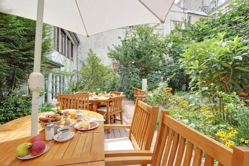 a patio table with a table cloth and umbrella at Hotel Alhambra in Paris