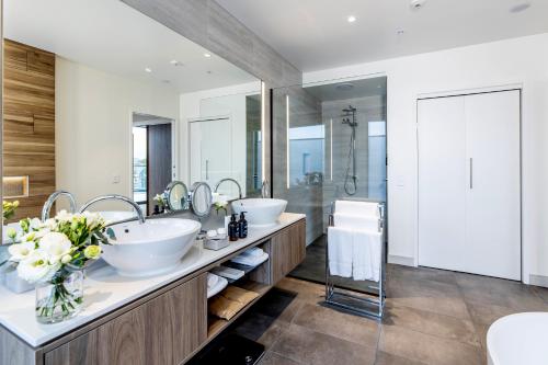 a bathroom with two sinks and a large mirror at Sudima Christchurch City in Christchurch