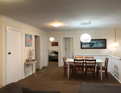 a dining room and living room with a table and chairs at The Castle - Goolwa Beach in Goolwa South