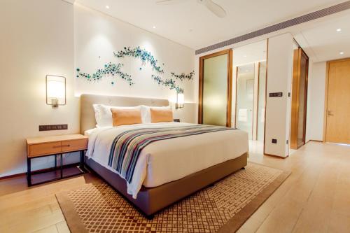 a bedroom with a large bed and a nightstand and a bed sidx sidx sidx at Sanya Conifer Resort in Sanya