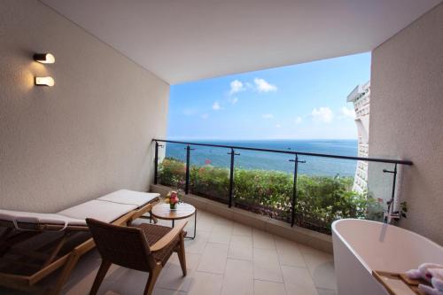 a bathroom with a tub and a view of the ocean at Sanya Conifer Resort in Sanya