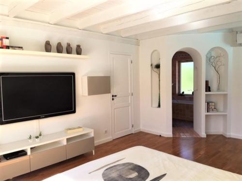 a living room with a flat screen tv on a wall at Appartements Les Pesquiers 2 Hyères Plage in Hyères