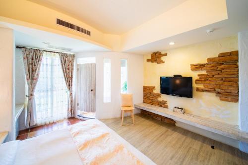 ein Wohnzimmer mit einem Flachbild-TV an der Wand in der Unterkunft Mong Shan Homestay in Kenting