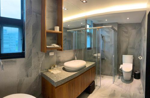a bathroom with a sink and a shower and a toilet at Tsang Kuo Resort in Wujie