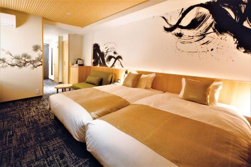 a hotel room with a bed and a painting on the wall at Nagi Kyoto Sanjo in Kyoto
