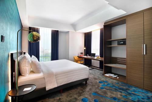 a hotel room with a bed and a desk at Swiss-Belinn Airport Surabaya in Sidoarjo