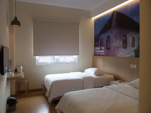 una camera d'albergo con due letti e una finestra di The City Hotel a Ambon