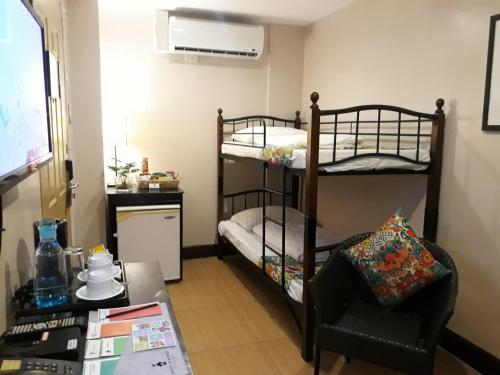 a room with two bunk beds and a chair at Hotel Kimberly Tagaytay in Tagaytay