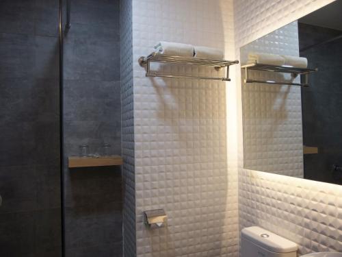 a bathroom with a toilet and a glass shower at The City Hotel in Ambon