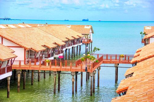 a row of houses on a pier in the water at AlexaPD Private Water Chalets in Port Dickson