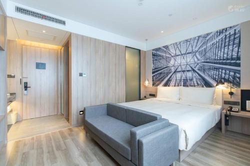 a bedroom with a large bed and a couch at Atour Hotel (Nanjing Zhushan Road Metro Station) in Jiangning