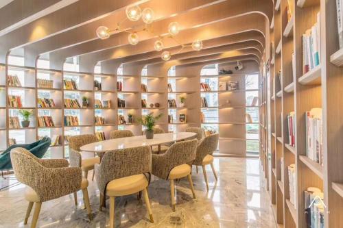 une salle à manger avec une table, des chaises et des étagères dans l'établissement Atour Hotel (Nanjing Zhushan Road Metro Station), à Jiangning