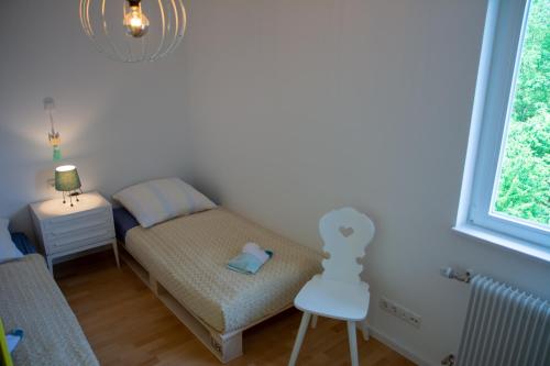 a small bedroom with a bed and a chair at Anna's Siedlungshäusle in Herrenberg