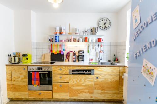 a kitchen with a wooden cabinet and a clock on the wall at Anna's Siedlungshäusle in Herrenberg
