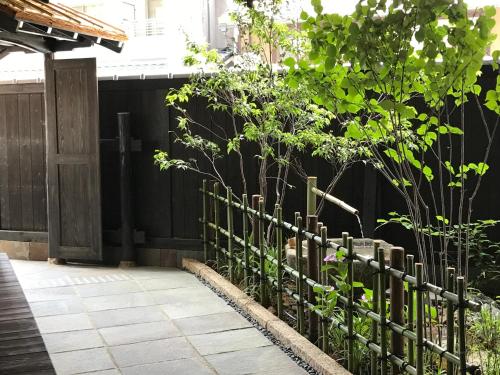 a garden area with a fence and a fence post at Kyomachiya Ryokan Sakura Urushitei in Kyoto