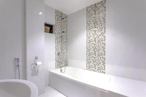 a bathroom with a tub and a toilet and a sink at Hotel Peace Plaza in Pokhara