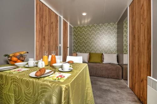 a table with a yellow table cloth and bread on it at Wellness Landhaus Parth in Ossiach