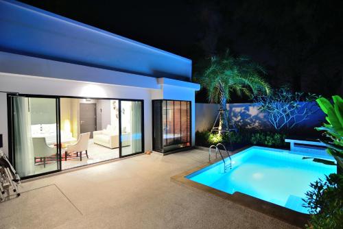 a backyard with a swimming pool and a house at Pumeria Resort Phuket - SHA Plus in Bang Tao Beach