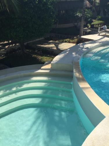 a swimming pool with blue water in a yard at Fortamu Twiga-House in Watamu