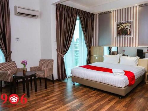 a hotel room with a bed and a table and chairs at 906 Premier Hotel in Melaka