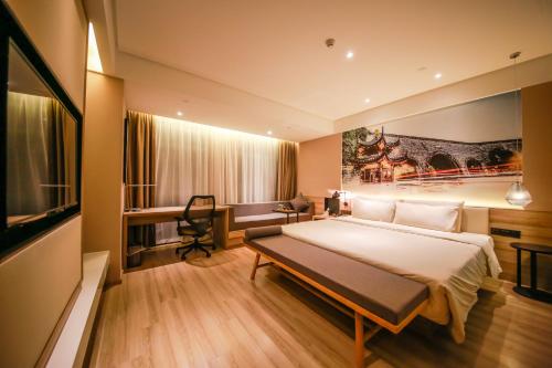 um quarto de hotel com uma cama grande e uma secretária em Atour Hotel (Nanjing Xianlin University City Shengchuangyuan) em Nanquim