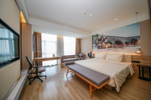 a large bedroom with a large bed and a desk at Atour Hotel (Nanjing Xianlin University City Shengchuangyuan) in Nanjing