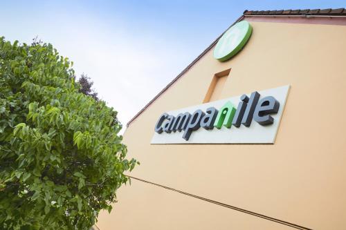 a sign on the side of a building with a clock at Campanile Colmar - Parc des Expositions in Colmar