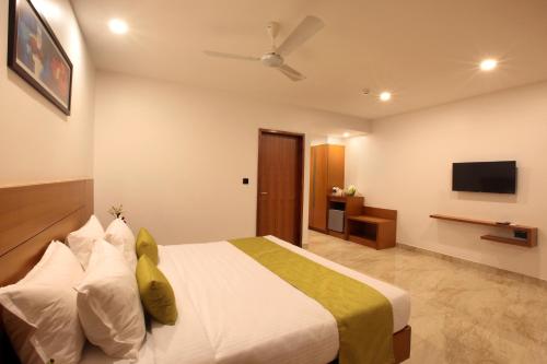 a hotel room with a bed and a television at Hotel Park Residency Thrissur in Trichūr