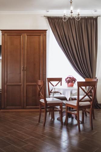 a dining room with a table and chairs and a curtain at Ekaterinoslav in Dnipro