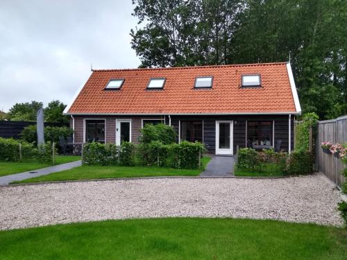 una casa con techo naranja y patio en Veers Vertier, en Veere