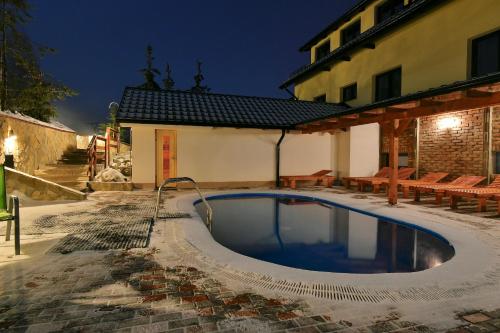 a swimming pool in front of a building at night at Wellness Hotel Fridrich in Horní Těrlicko
