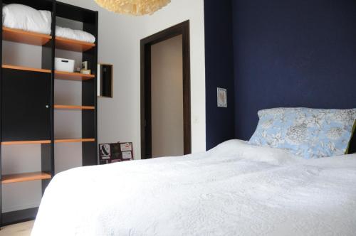 a bedroom with a white bed and a blue wall at Acquachiara in Ponte Tresa