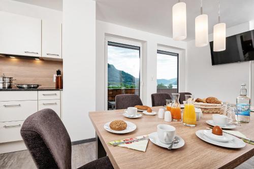 a kitchen and dining room with a wooden table and chairs at Wellness Landhaus Parth in Ossiach