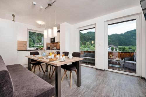a dining room and kitchen with a table with chairs at Wellness Landhaus Parth in Ossiach