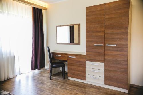 a desk with a mirror and a chair in a room at Pensiunea Andres in Sovata