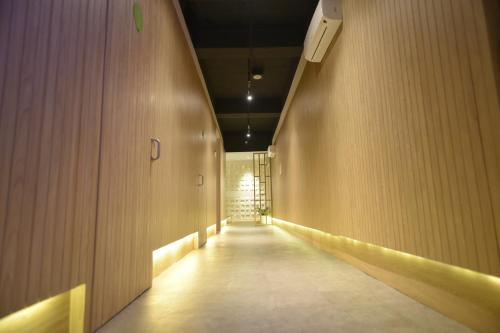 un pasillo con un largo pasillo con paredes de madera en Whiz Capsule Hotel Thamrin Jakarta, en Yakarta