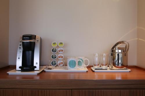 a coffee maker and cups on a wooden shelf at Guam Reef Hotel in Tumon
