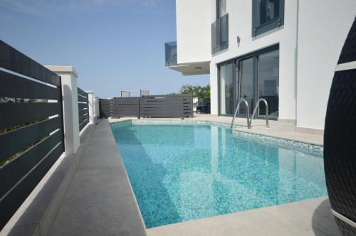 - une piscine en face d'une maison dans l'établissement Beautiful New House, à Crikvenica
