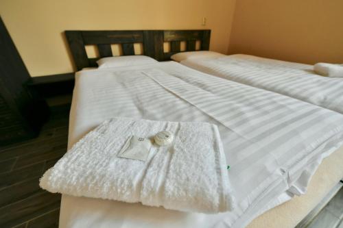 two beds with white sheets and a ring on them at Wellness Hotel Fridrich in Horní Těrlicko