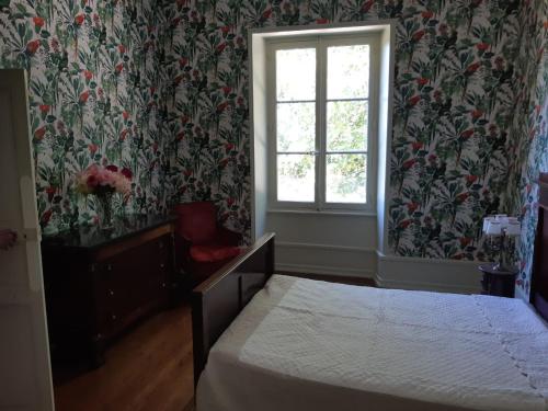 a bedroom with a bed and a window at La maison des pères in Charolles