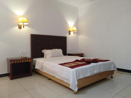um quarto com uma cama grande e duas mesas de cabeceira em Excelsior Resort em Dili