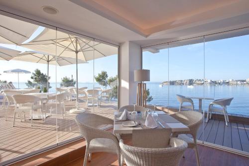 a dining room with a view of the water at Aparthotel Ponent Mar in Palmanova