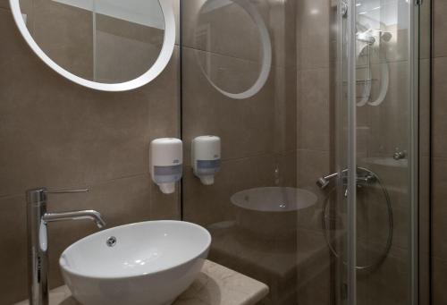 a bathroom with a sink and a glass shower at Nelly's Apartments in Tolo